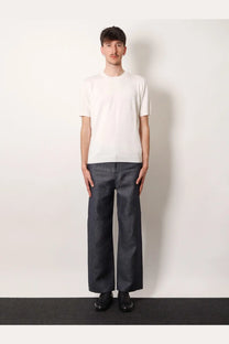 Fendi men’s white cotton and cashmere sweater paired with a minimalist white short-sleeved cotton t-shirt and dark gray trousers