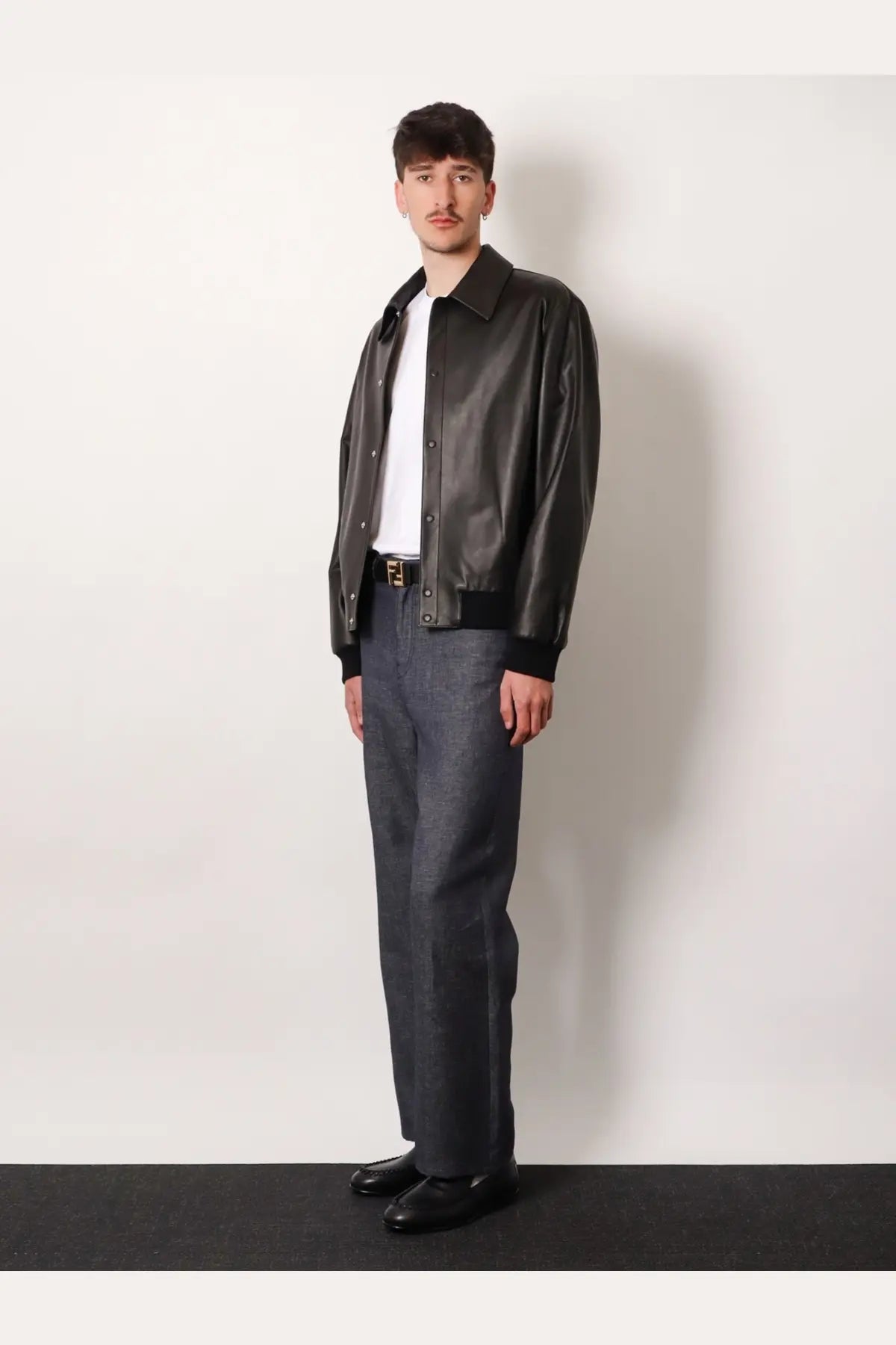 Black leather bomber jacket with ribbed cuffs and collar paired with fendi men cotton and silk blue jeans
