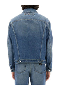 Fendi men’s blue denim jacket with subtle faded wash and contrasting black stitching featuring logo patch on collar