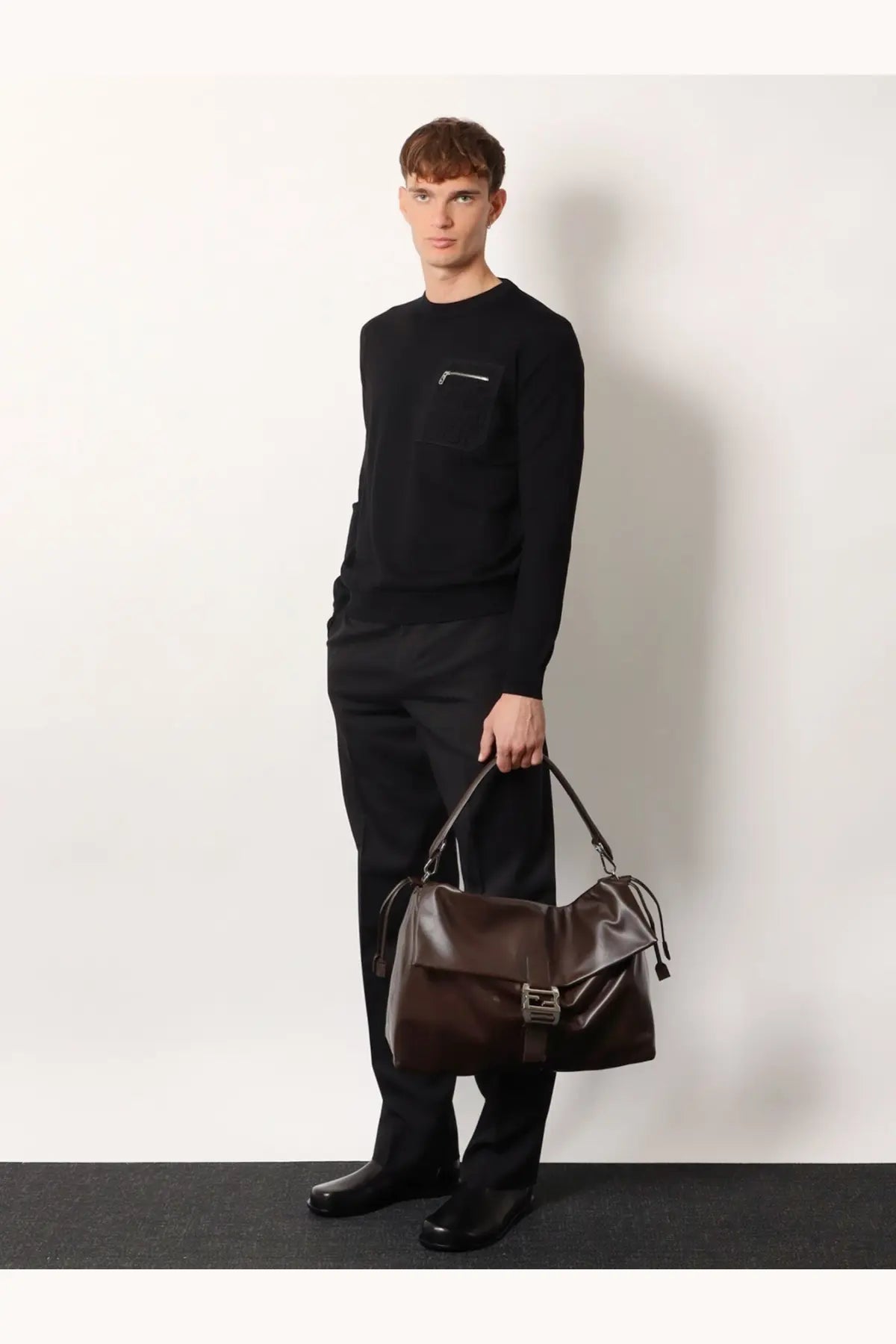 Brown leather duffel bag with metallic buckle and drawstring closure in mens fendi flux maxi messenger style