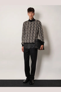 Black and white geometric patterned knit sweater with high collar paired with men’s Fendi Lui large black nylon crossbody bag