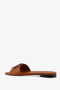 Fendi women’s baguette tan leather slide sandals with black rubber sole and metallic logo clasp