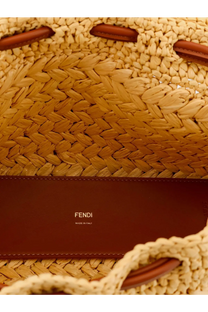 A tan woven raffia Fendi mamma baguette medium crossbody bag with brown leather handles and logo strap white background