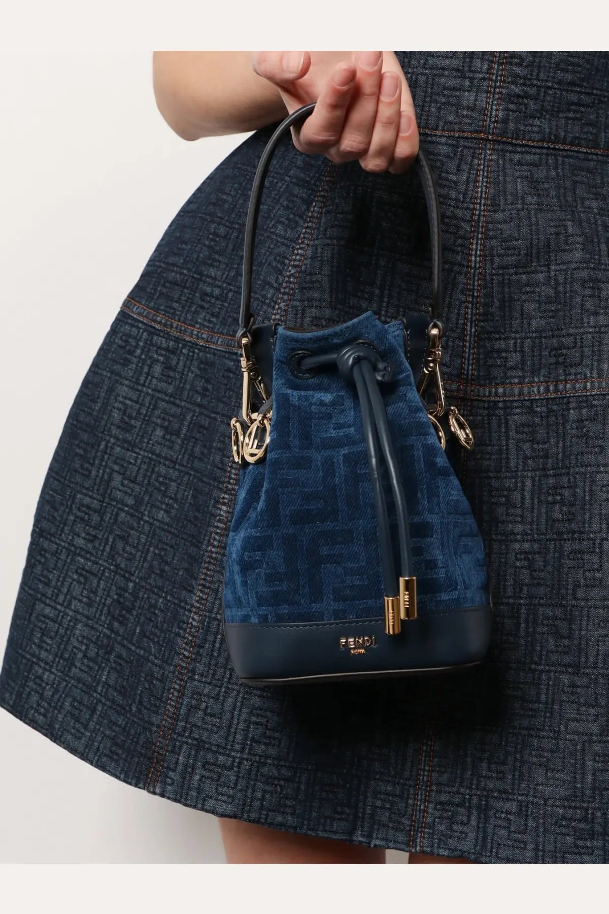 Fendi women’s navy blue velvet bucket bag with ff logo pattern, black leather handles, and gold hardware accents