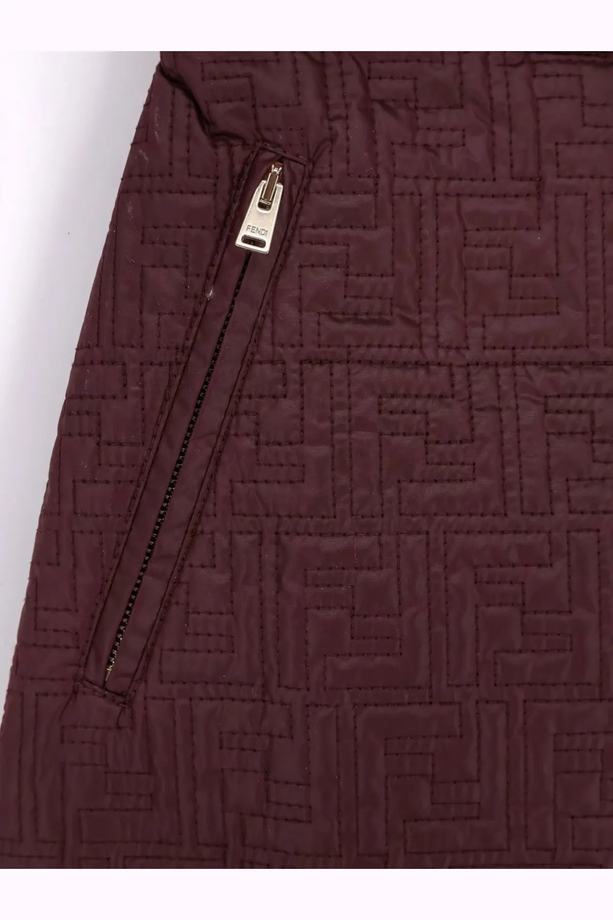 A maroon quilted fendi jacket featuring a repeating monogram pattern and a silver-toned zipper pull