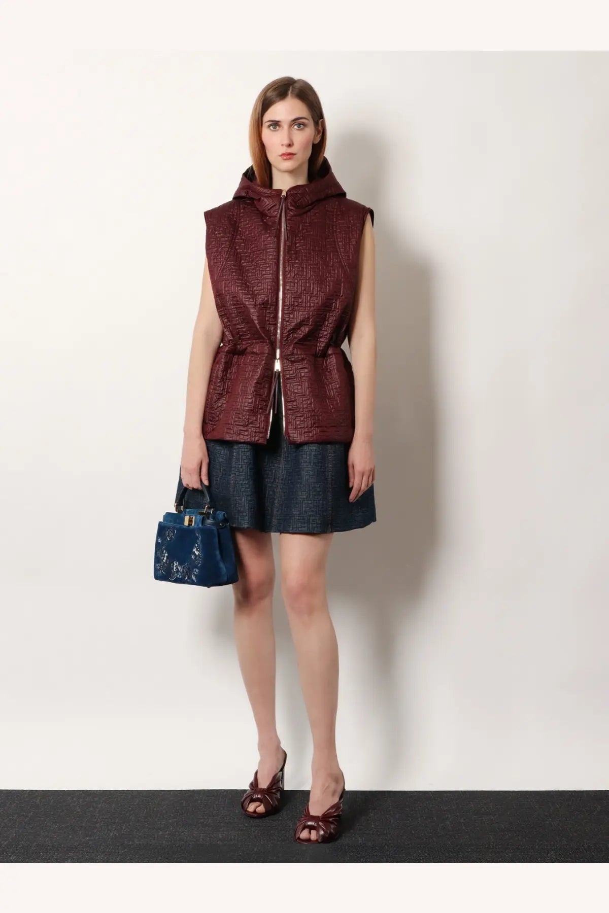 Fendi women’s quilted nylon vest in burgundy with hood, central zipper, and cinched waist for stylish warmth