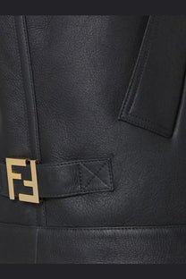 Black leather Fendi belt with gold-tone FF logo buckle paired with Fendi women’s sleeveless sheepskin jacket black