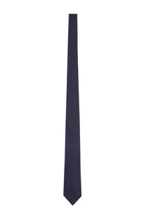 A sleek navy blue silk Ferragamo men’s cravatta with subtle sheen and small red square logo at the tip