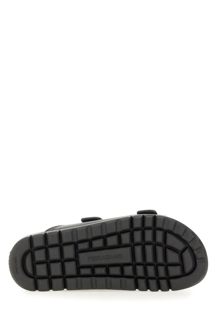 Black rubber sole with grid pattern and marc jacobs embossed on ferragamo men’s double strap sandal black back side