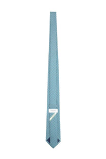 Ferragamo men’s silk tie in light blue with a subtle geometric pattern and white label at the collar end