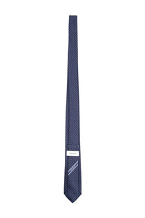 Ferragamo men’s navy blue silk tie with subtle white dot pattern and ferragamo brand label at the base