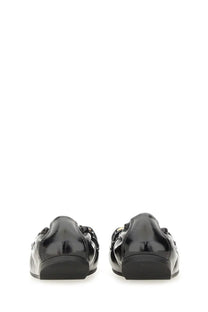 Back view of ferragamo women’s deconstructed loafer black patent leather with glossy finish and chain detailing