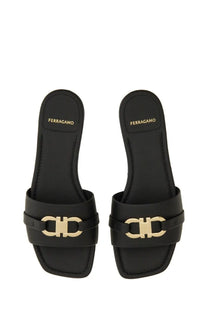 Ferragamo women’s black leather slide sandals with gold-tone double c logo buckle