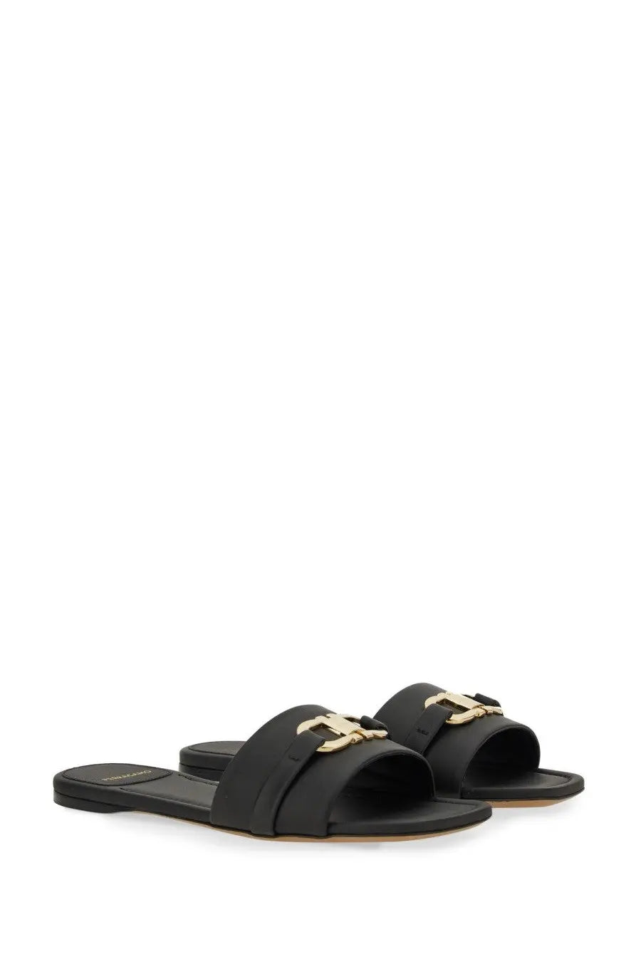 Ferragamo women’s black leather slide sandal featuring a gold-tone logo buckle on the front strap