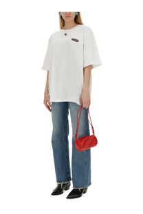 Vibrant red quilted cylindrical crossbody bag with thin matching straps paired with fiorucci women’s candy patch shirt white