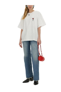 A vibrant red round crossbody bag with a braided strap complementing fiorucci womens lollipop print shirt white