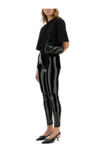 Black patent leather leggings with glossy finish and side zipper detail paired with fiorucci women’s black shirt