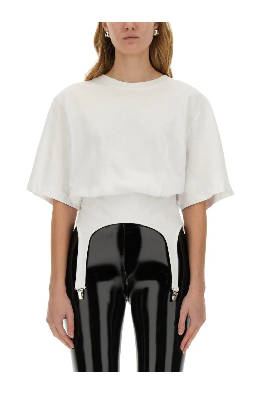 Fiorucci women’s white cropped tee with wide flared sleeves paired with high-waisted black patent leather pants and silver suspenders