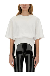 Fiorucci women’s white cropped tee with wide flared sleeves paired with high-waisted black patent leather pants and silver suspenders