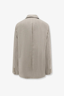The Frankie Shop women’s beige virgin wool blazer features a subtle vertical weave and black trim on the collar