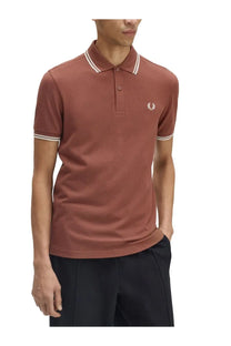 Fred Perry men’s rust-colored polo shirt with white collar and sleeve trim featuring embroidered chest logo