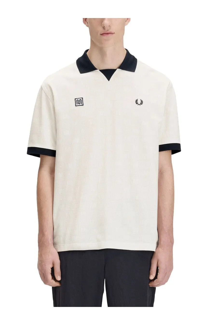 Fred Perry men’s cream-colored short-sleeved polo shirt with black collar, cuffs, and embroidered chest logo
