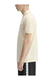 Cream-colored fred perry men’s polo shirt with classic collar short sleeves and embroidered logo on the chest