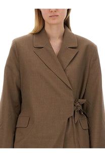 Ganni women’s asymmetrical blazer in taupe with a notched lapel and self-tie belt at the waist