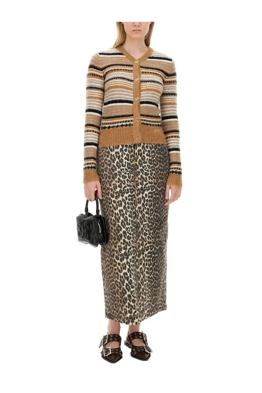 A woman wearing ganni women’s beige striped knit cardigan with gold-tone buttons over a leopard print skirt