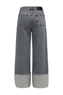 Ganni women’s wide-leg double fly jeans in faded gray denim with rolled cuffs and black brand label at waistband