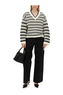 Black and white striped v-neck sweater with ribbed cuffs and hem paired with Ganni women’s herringbone pants black