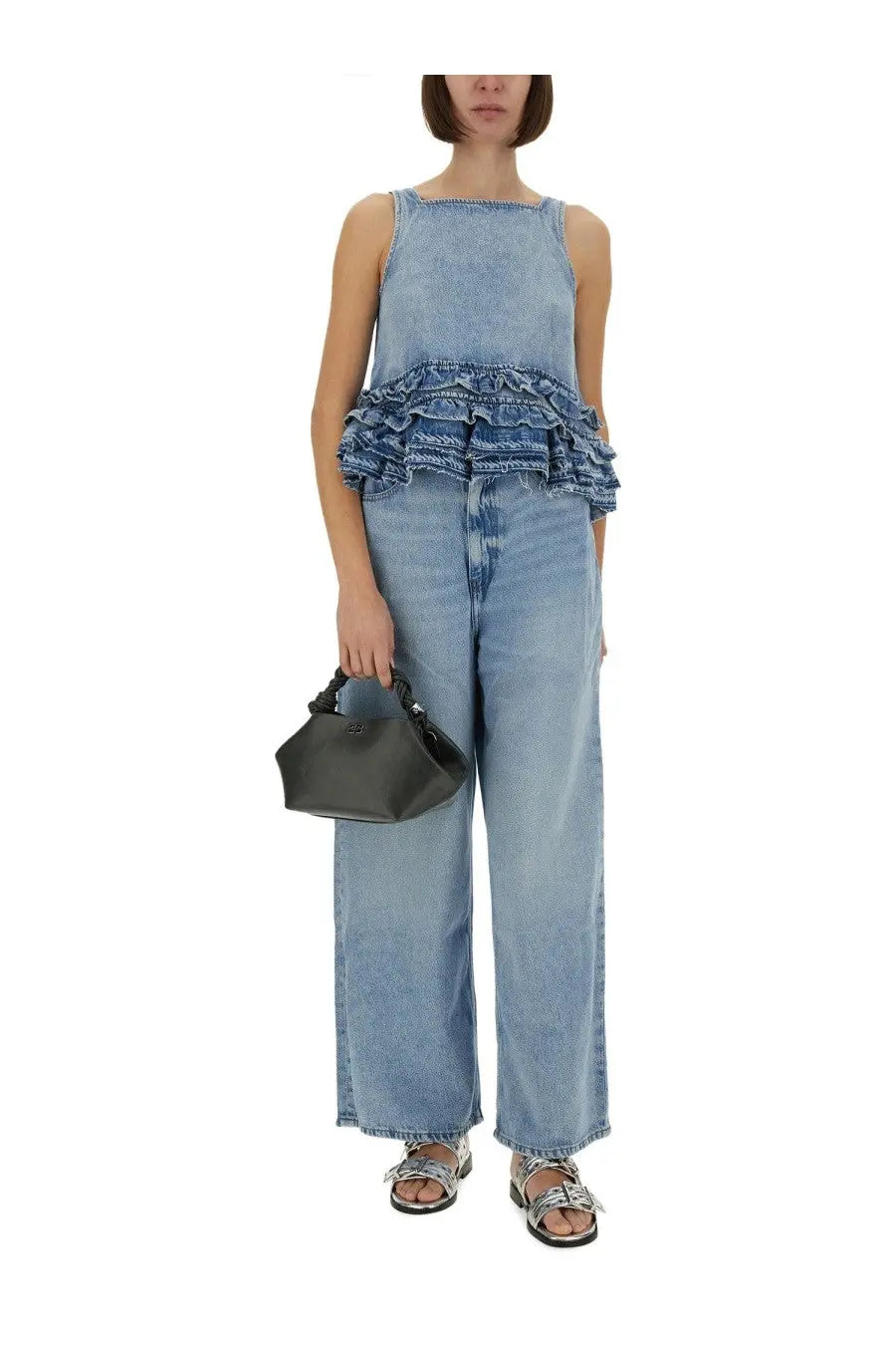 Ganni women’s baggy blue jeans paired with a black leather mini handbag with structured hexagonal shape and top handle