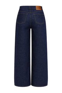 Dark blue denim wide-leg jeans with brown leather brand patch at waistband showing back side by ganni women