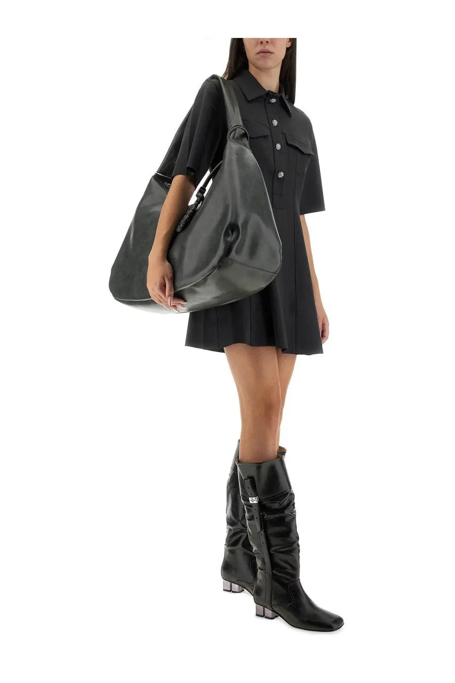 Black leather hobo bag with drawstring top and adjustable shoulder strap shown with Ganni women’s mini dress grey
