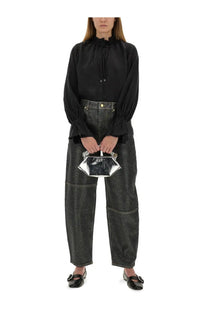 A sleek silver clutch with a reflective metallic finish and hexagonal shape paired with ganni womens stary jeans
