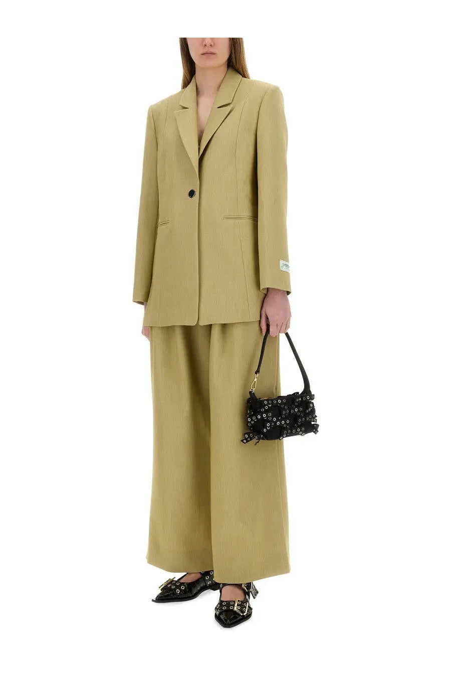 Black studded mini handbag with gold tone hardware paired with beige ganni women’s twill suit pants