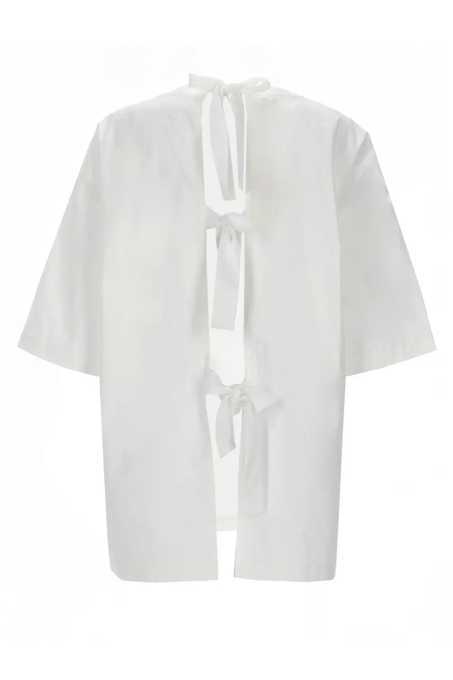 The garment women’s blusa cyprus white loose fitting blouse with short sleeves and back tie detail shown from the back