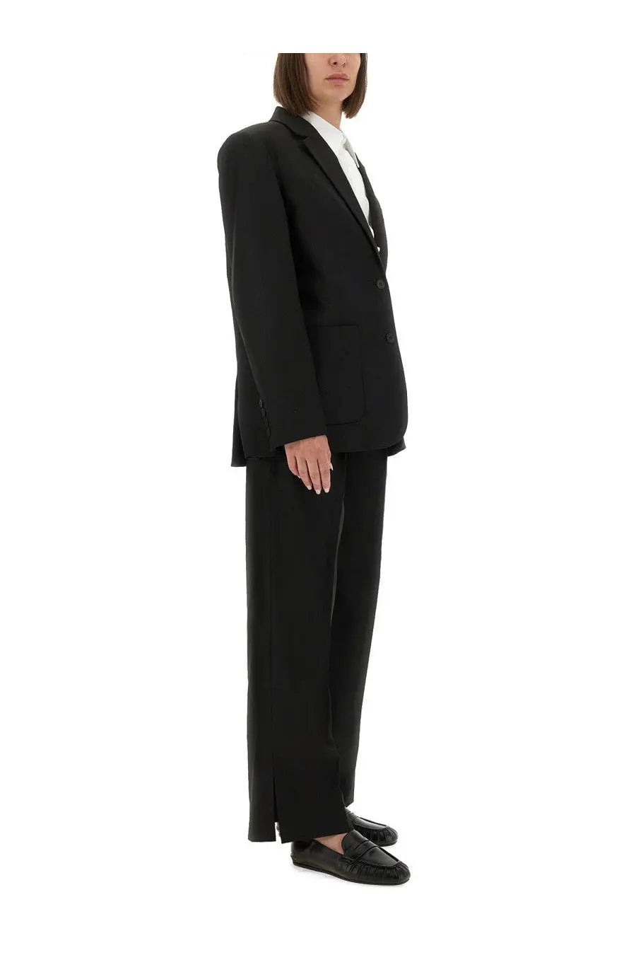 The garment women’s pants pluto black paired with a black tailored blazer with sleek minimalist design and subtle peak lapels