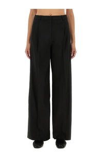 Black wide-leg tailored trousers with structured fit and subtle pleats at waistband from the garment women pants pluto black
