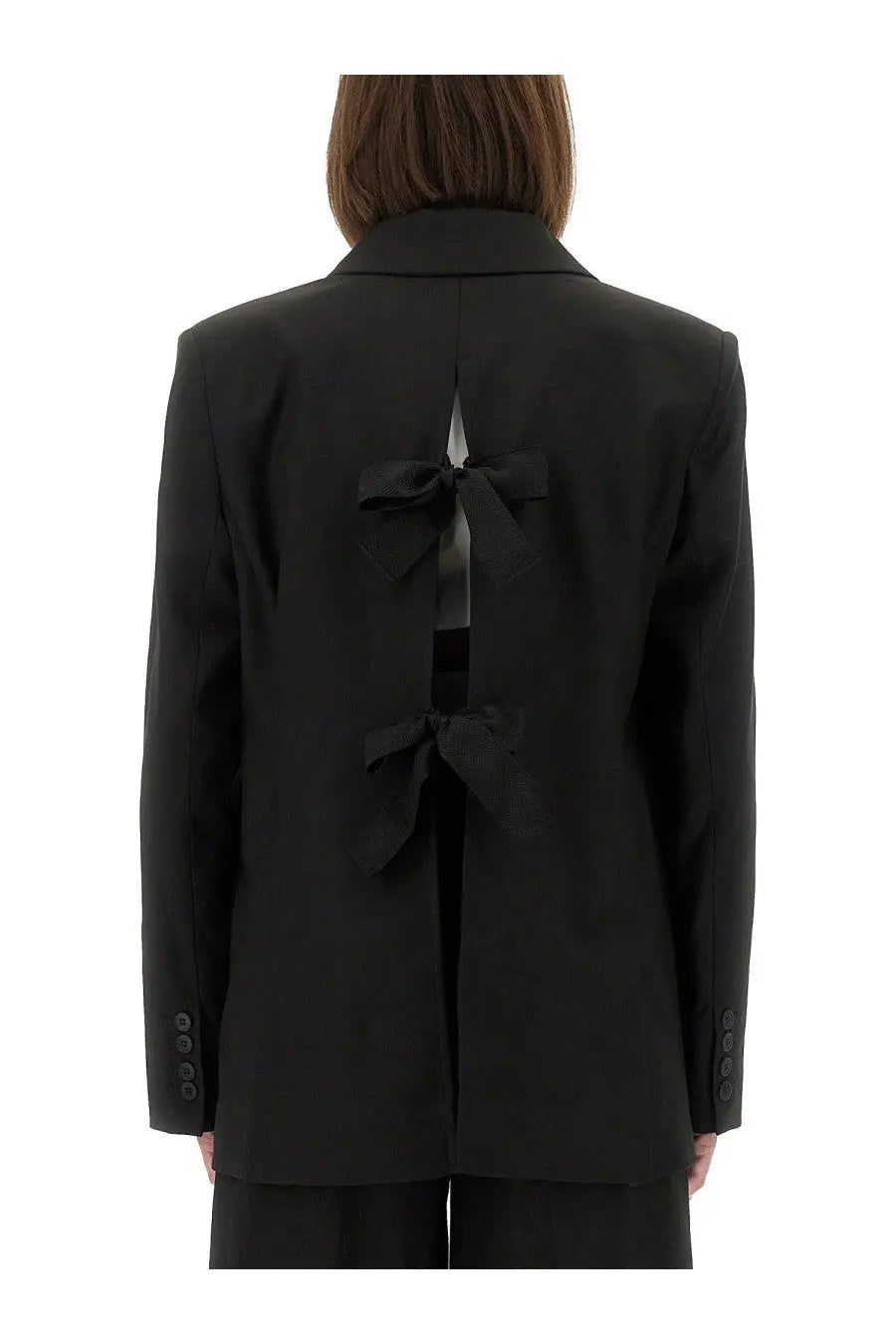 The garment women’s pluto blazer black showing the back with a central bow detail on a tailored black blazer