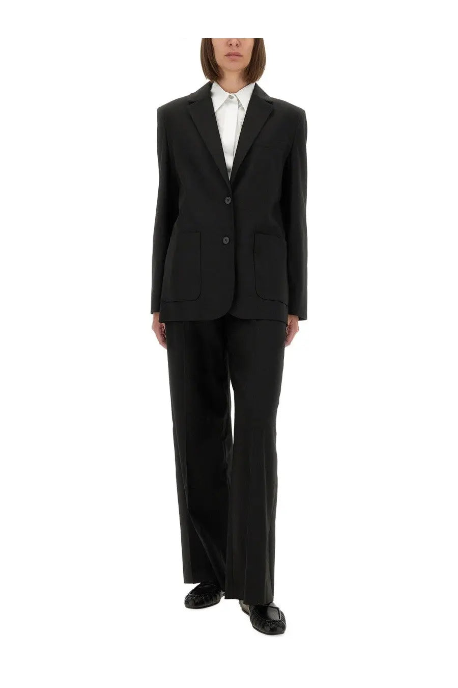 The Garment women’s Pluto blazer in black tailored fabric with notched lapels and two front buttons paired with wide-leg trousers