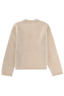 The garment women’s roma boyfriend sweater in cream features a soft knit texture with a crew neck and long sleeves