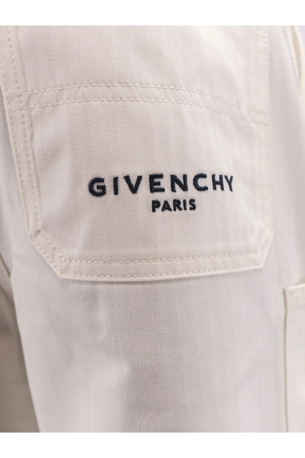 Givenchy men’s cotton Bermuda shorts white paired with a cream-colored herringbone jacket with black chest embroidery