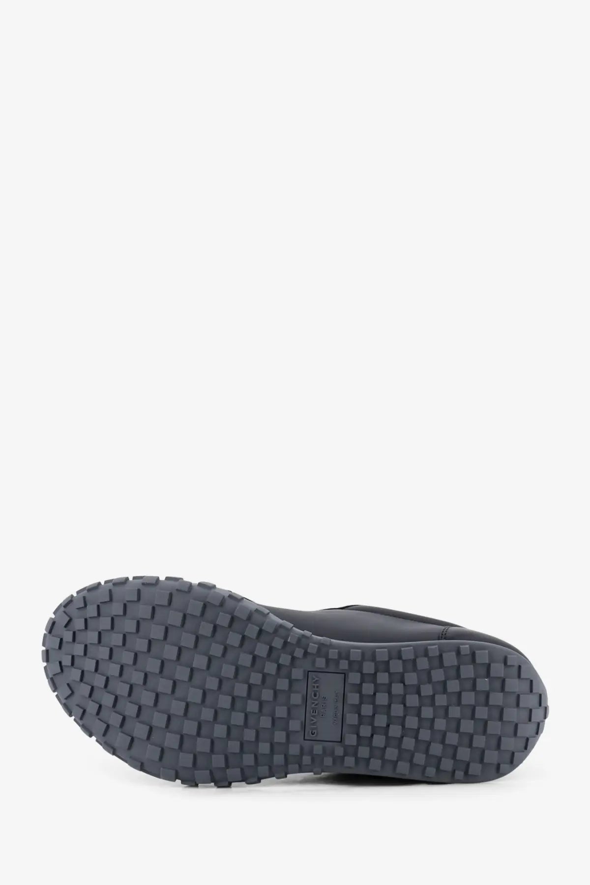 Dark gray rubber sole with textured grid pattern and givenchy logo on men’s black leather sneakers