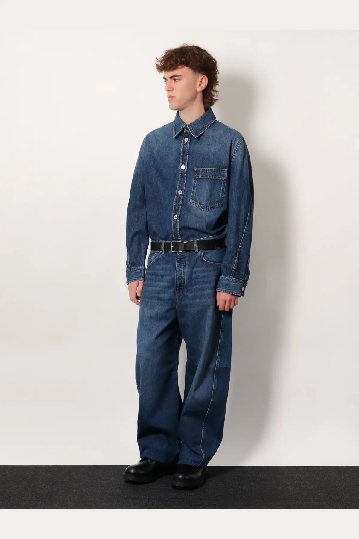 Givenchy men’s blue denim overshirt with button-up front and chest pocket worn by model on plain background
