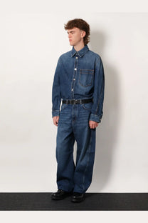 Givenchy men’s blue denim overshirt with button-up front and chest pocket worn by model on plain background