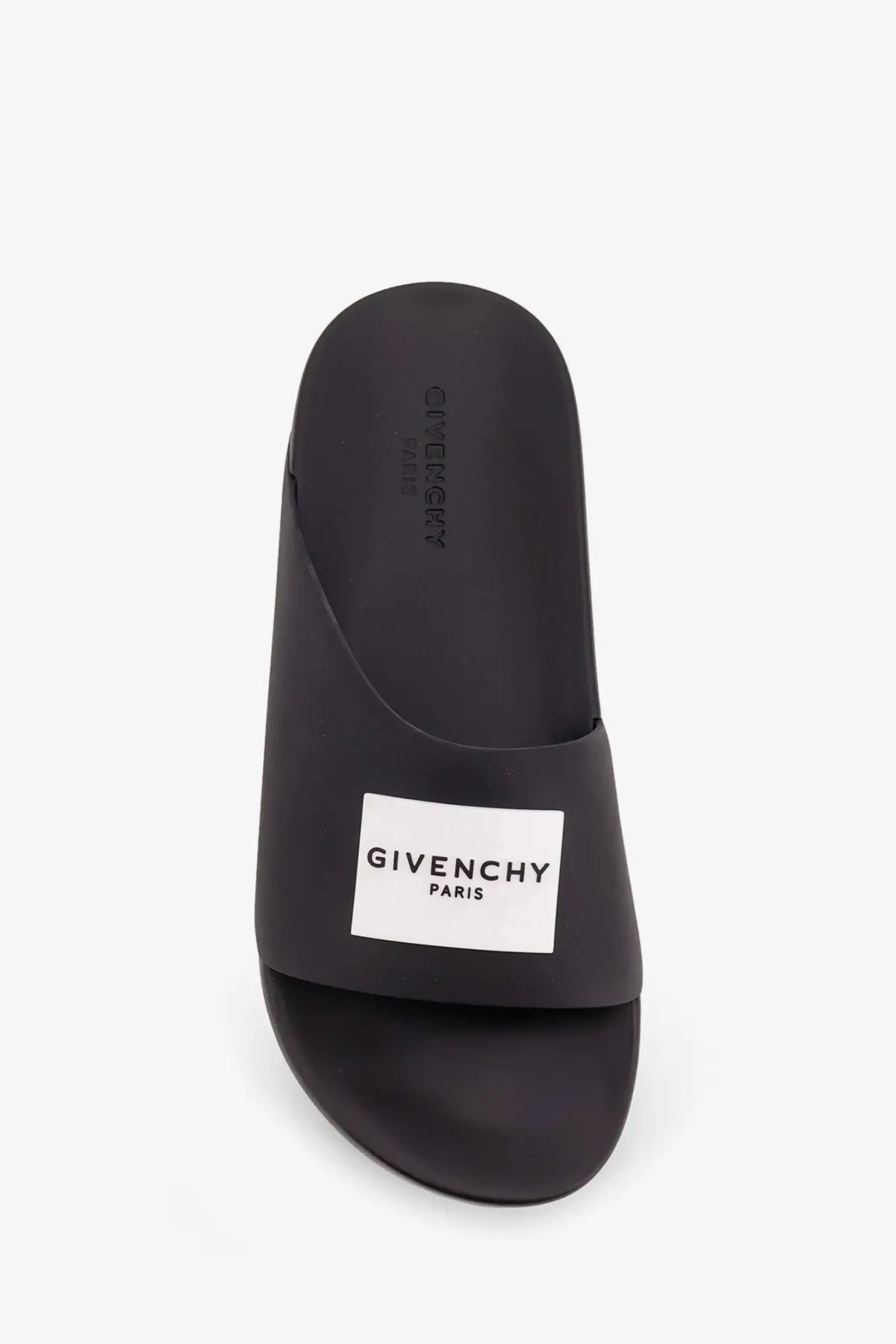 Givenchy men’s rubber slide sandal in black with minimalist design and white rectangular logo patch on the footbed