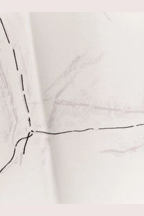 A close-up of a white cotton Givenchy women’s shirt showing faint pencil sketch markings and black stitching lines