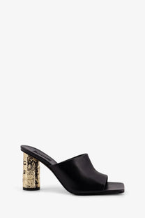 Givenchy women’s black leather mule sandal with a gold foil block heel featuring embossed lettering