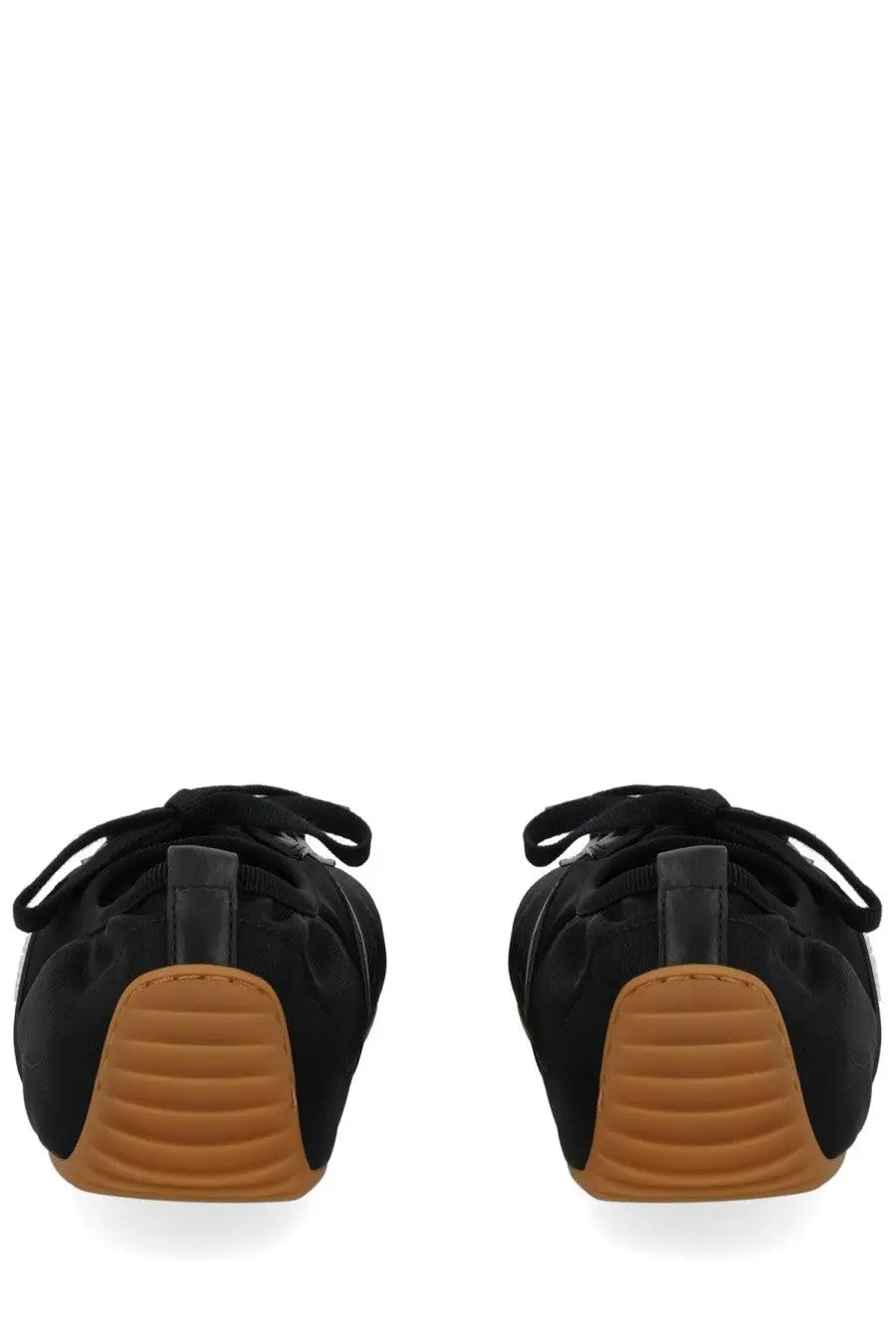 Givenchy women’s minimal slim sneaker in black canvas with tan rubber soles and black laces shown from the back